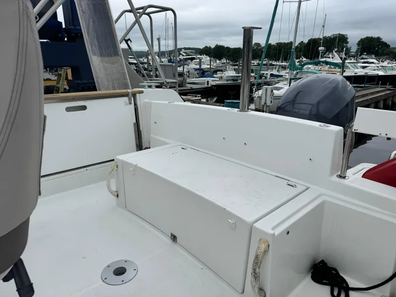 Slide: The Image of 2015 Jeanneau Cap Camarat 6.5 WA boat interior at marina, featuring seating and storage. - 8