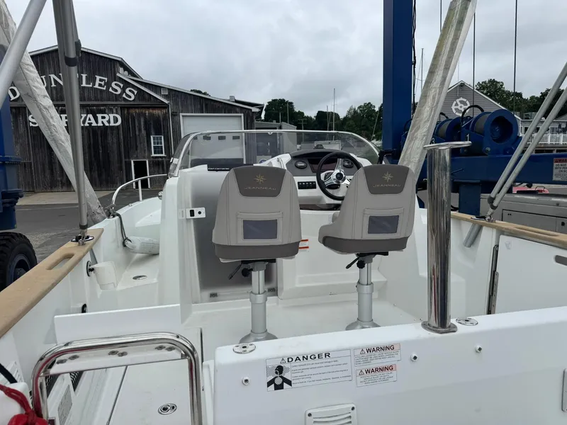 Slide: The Image of 2015 Jeanneau Cap Camarat 6.5 WA boat interior at shipyard, featuring dual seats and steering console. - 9