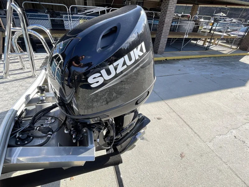 Slide: The Image of 2025 South Bay 224RSLE with Suzuki outboard motor in a marina setting. - 10
