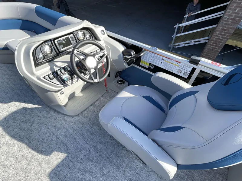 Slide: The Image of 2025 South Bay 224RSLE boat interior with modern steering console and plush seating. - 16