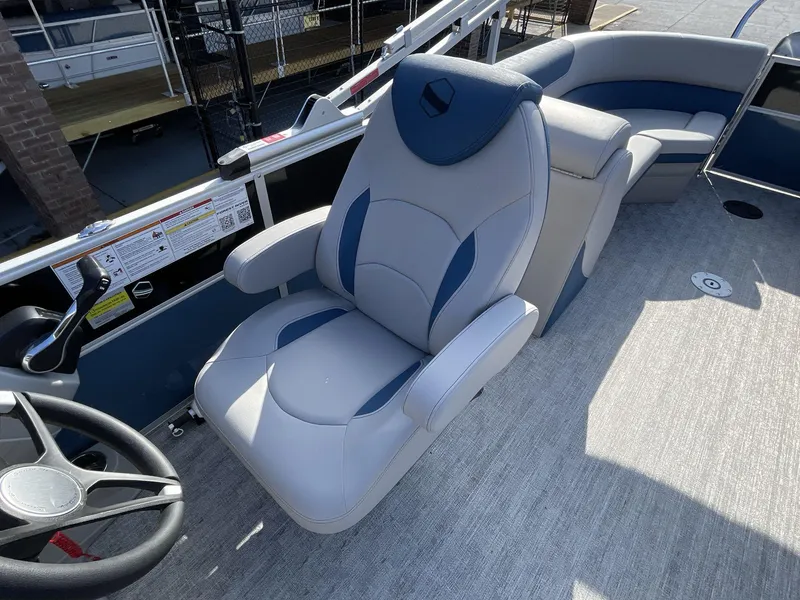 Slide: The Image of 2025 South Bay 224RSLE boat interior with plush seating and steering wheel. - 19