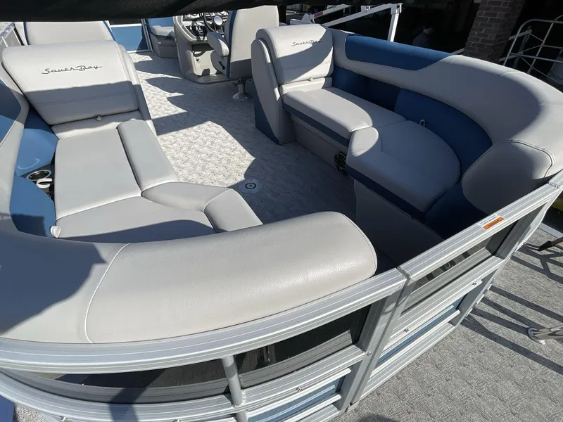 Slide: The Image of 2025 South Bay 224RSLE pontoon boat interior with gray and blue seating. - 9