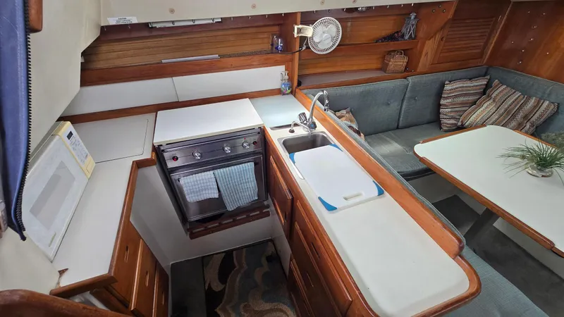 Slide: The Image of Interior of 1992 Catalina 30 Tall Rig sailboat with kitchen and seating area. - 14