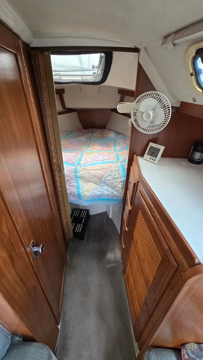 Slide: The Image of 1992 Catalina 30 Tall Rig cabin interior with bed, fan, and wooden cabinetry. - 19