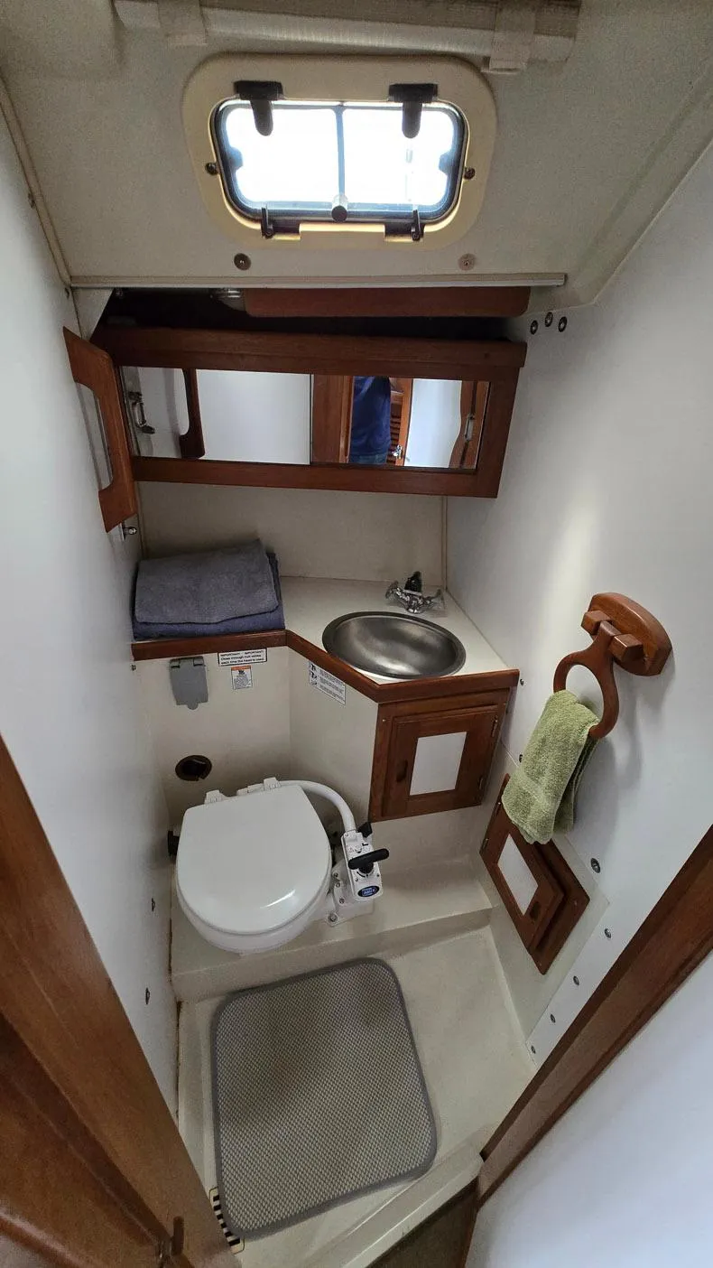 Slide: The Image of Compact bathroom in a 1992 Catalina 30 Tall Rig sailboat, featuring sink and toilet. - 21