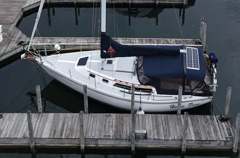 Slide: The Image of 1992 Catalina 30 Tall Rig sailboat docked, featuring solar panel and navy canopy. - 4