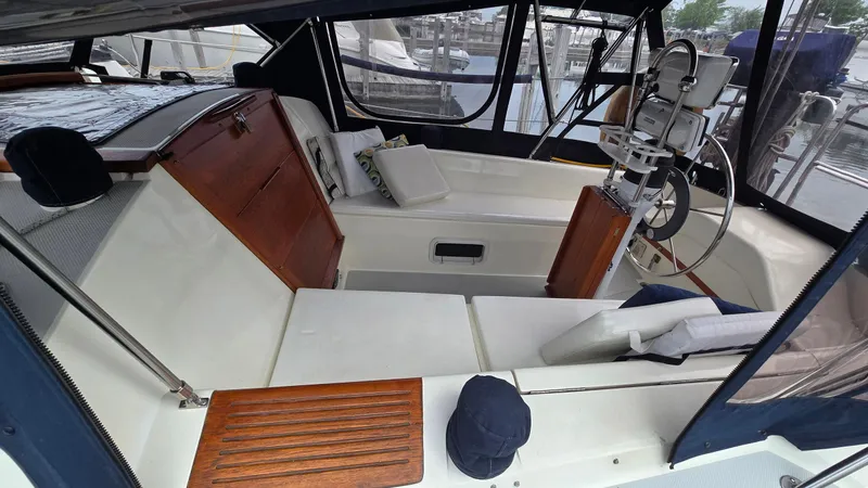 Slide: The Image of 1992 Catalina 30 Tall Rig sailboat cockpit with seating and steering wheel, docked at marina. - 8
