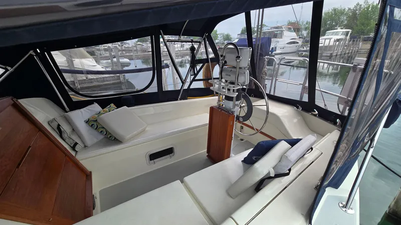 Slide: The Image of 1992 Catalina 30 Tall Rig sailboat interior with cushions, steering wheel, and marina view. - 9