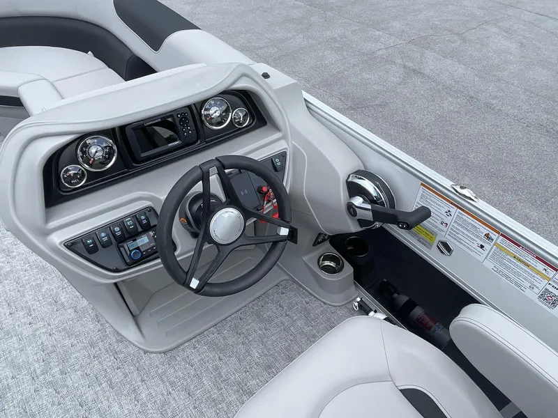 Slide: The Image of 2025 South Bay 224RSLE boat dashboard with steering wheel and controls. - 13