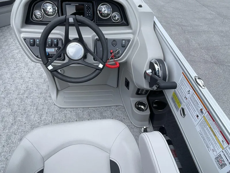 Slide: The Image of 2025 South Bay 224RSLE boat cockpit with steering wheel, controls, and dashboard instruments. - 18