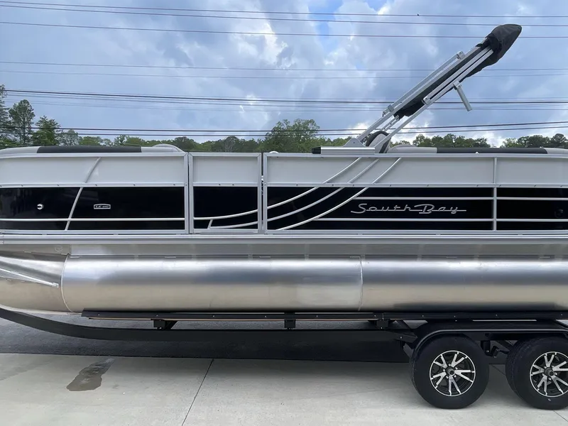 Slide: The Image of 2025 South Bay 224RSLE pontoon boat on trailer under cloudy sky. - 3