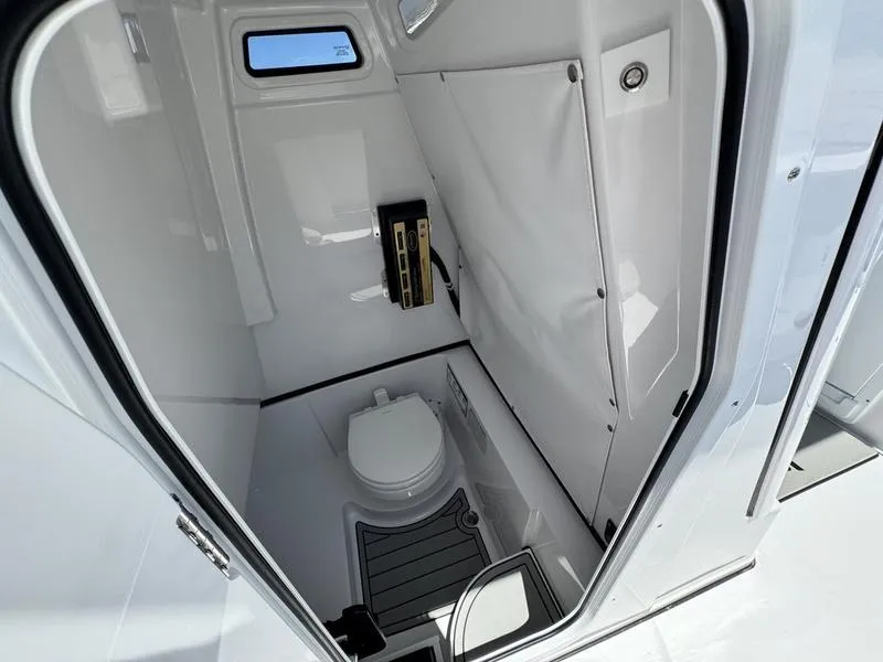 Slide: The Image of 2025 Sportsman Heritage 261 boat interior with compact marine toilet and sleek design. - 12