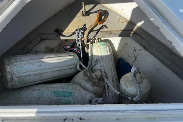 Slide: The Image of Storage compartment of a 1999 Contender 27 Open Center Console with boat fenders and ropes. - 14