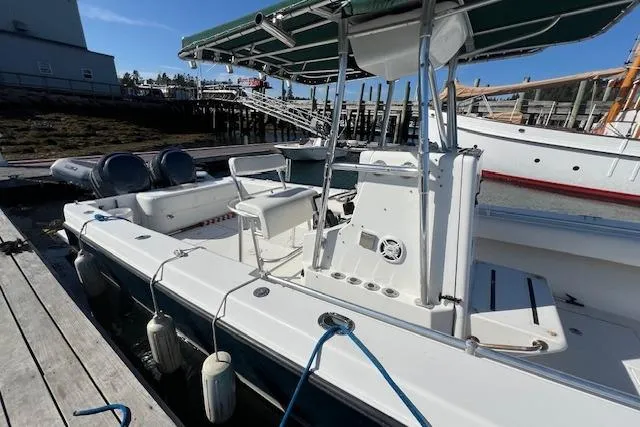 Slide: The Image of 1999 Contender 27 Open Center Console boat docked, featuring dual engines and a green canopy. - 19
