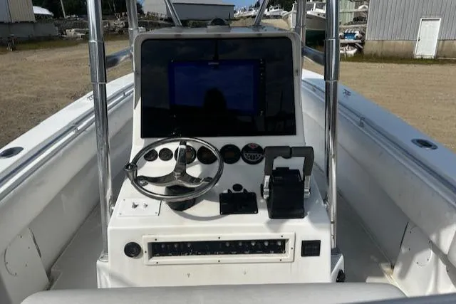 Slide: The Image of 1999 Contender 27 Open Center Console boat dashboard with steering wheel and controls. - 2