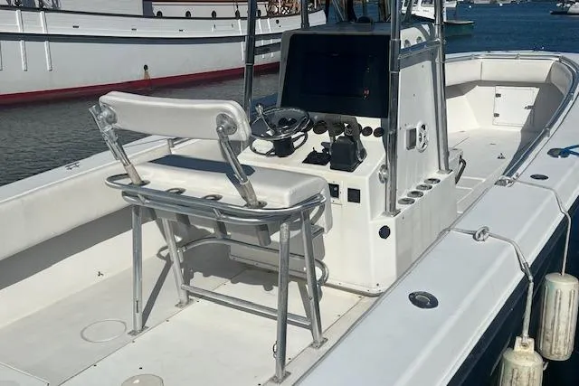 Slide: The Image of 1999 Contender 27 Open Center Console boat with helm and seating, docked in marina. - 20