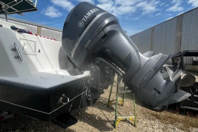 Slide: The Image of 1999 Contender 27 Open Center Console with Yamaha outboard motor, parked outdoors. - 23