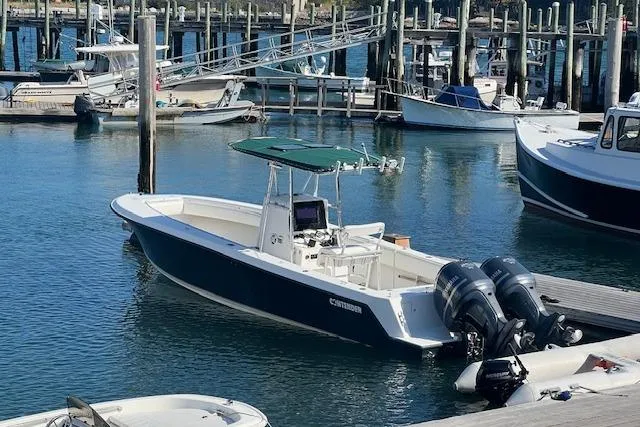 Slide: The Image of 1999 Contender 27 Open Center Console boat docked in a marina with twin engines. - 24