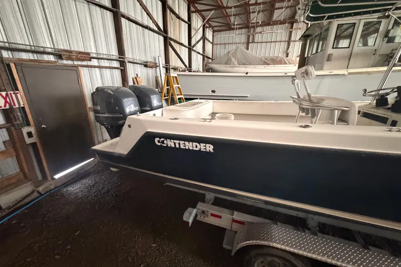 Slide: The Image of 1999 Contender 27 Open CC boat in storage, featuring twin Yamaha 250 engines. - 29