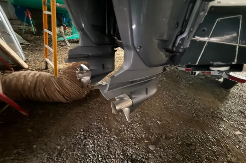 Slide: The Image of Outboard motors of a 1999 Contender 27 Open CC boat on gravel surface. - 30