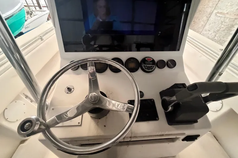 Slide: The Image of Console of a 1999 Contender 27 Open CC boat with steering wheel and controls. - 36
