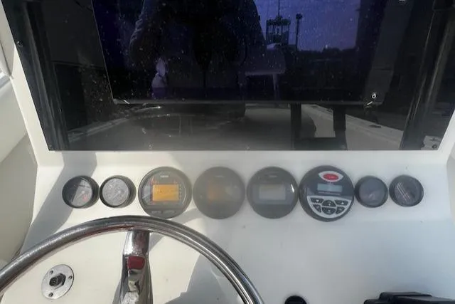 Slide: The Image of Dashboard of a 1999 Contender 27 Open Center Console boat with various gauges and controls. - 4