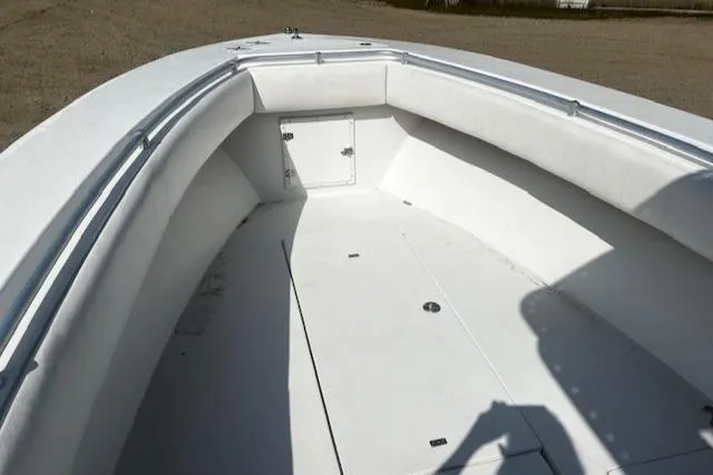 Slide: The Image of 1999 Contender 27 Open Center Console boat interior, featuring spacious white deck and storage compartments. - 7