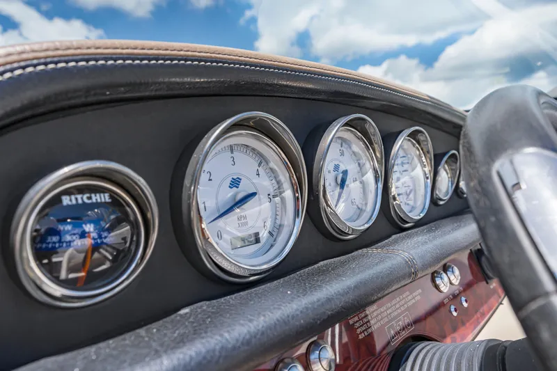 Slide: The Image of Dashboard of 2008 Four Winns F224 boat with gauges and compass under blue sky. - 13