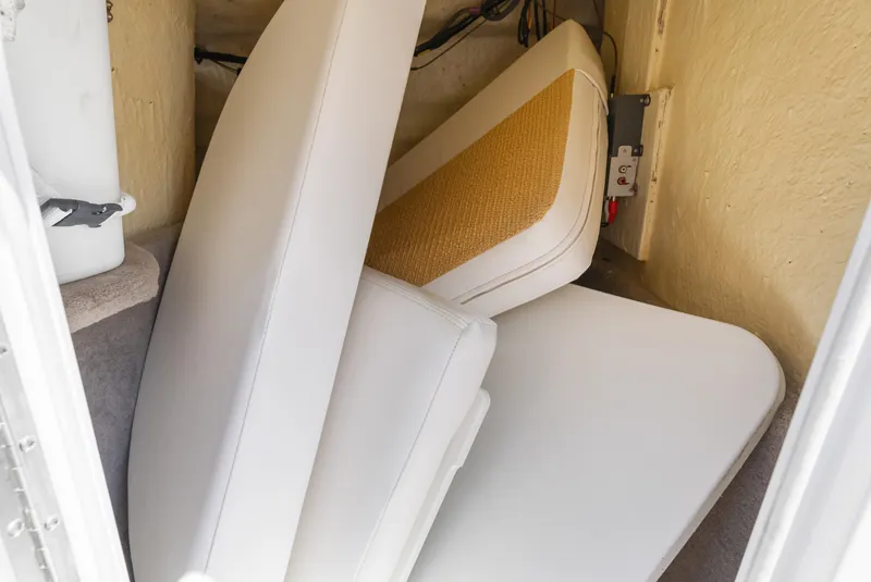 Slide: The Image of 2008 Four Winns F224 boat interior storage with white cushions and electrical panel. - 21