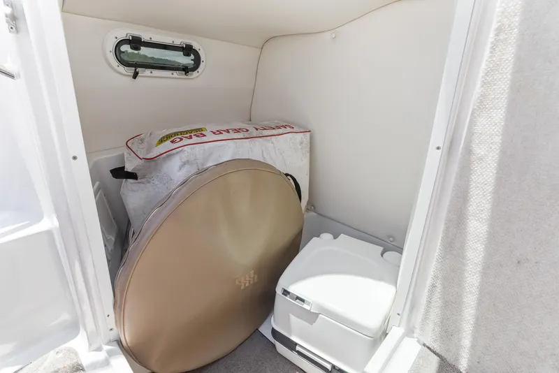 Slide: The Image of 2008 Four Winns F224 boat interior with portable toilet and storage gear. - 22