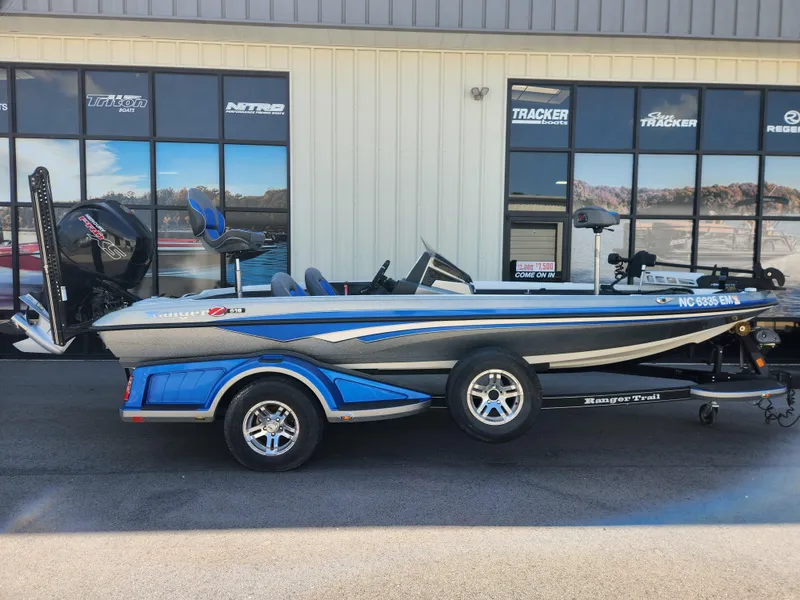 The Image of 2019 Ranger Z518 boat with blue accents parked outside a showroom. - 0