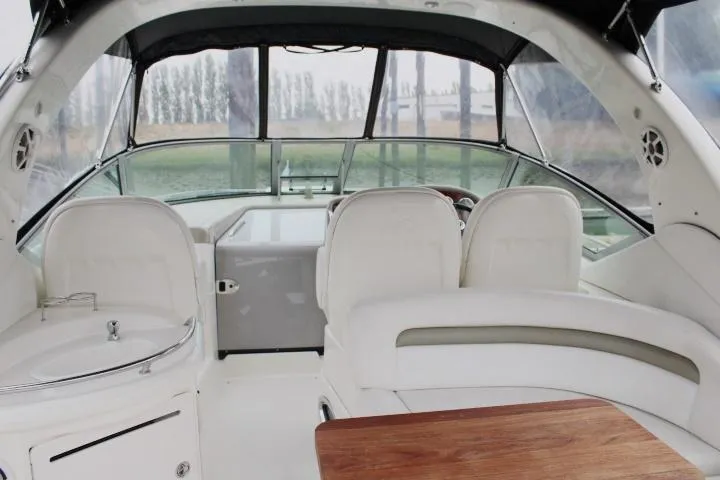 Slide: The Image of 2007 Sea Ray 340 Sundancer cockpit with white seating and wooden table. - 15