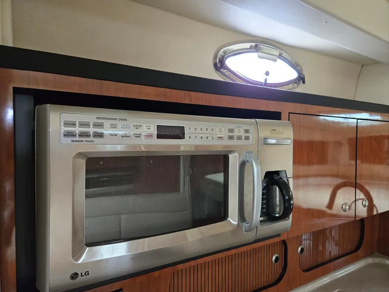 Slide: The Image of LG microwave in 2007 Sea Ray 340 Sundancer yacht kitchen, wood cabinetry, porthole window. - 44