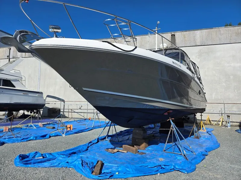 Slide: The Image of 2007 Sea Ray 340 Sundancer yacht on stands, covered with blue tarps, in a boatyard. - 5