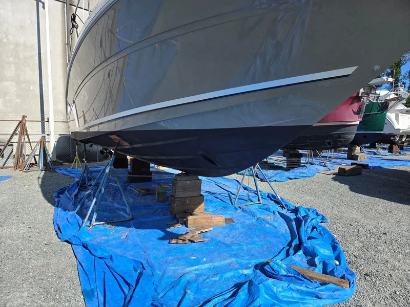 Slide: The Image of 2007 Sea Ray 340 Sundancer on stands, covered with blue tarps, in a boatyard. - 6