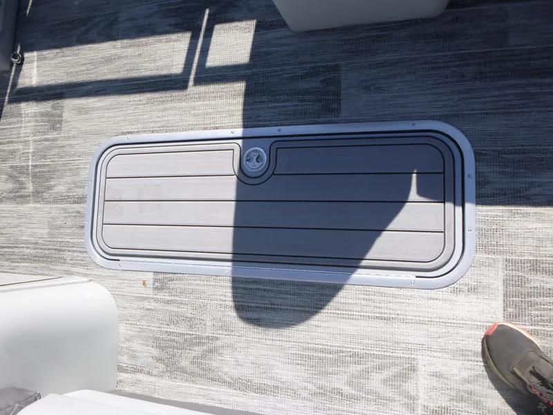 Slide: The Image of 2024 Ranger Reata 223C boat deck with storage compartment and textured flooring. - 13