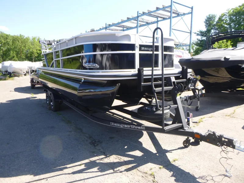Slide: The Image of 2024 Ranger Reata 223C pontoon boat on trailer in outdoor setting. - 3