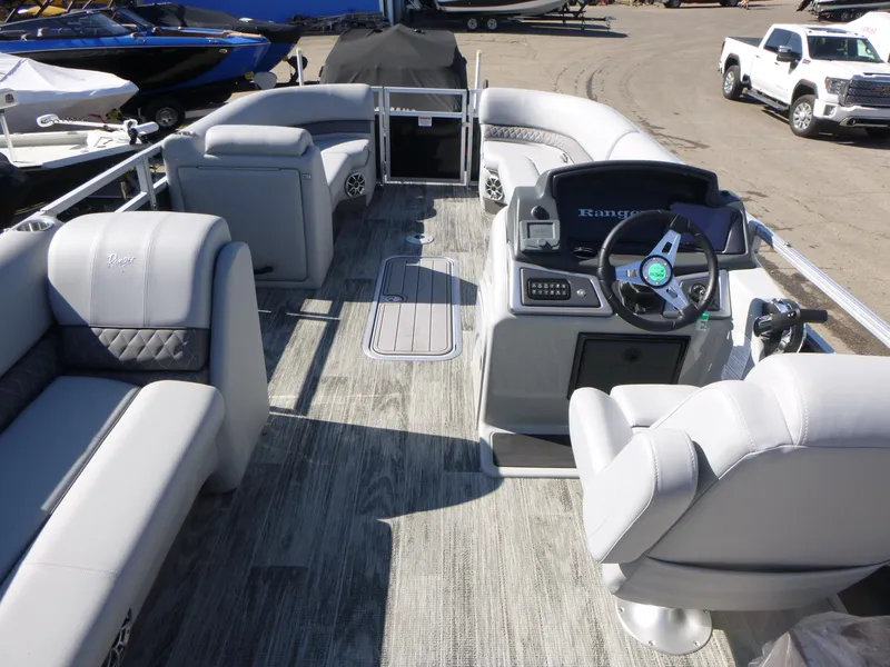 Slide: The Image of 2024 Ranger Reata 223C pontoon boat interior with plush seating and modern dashboard. - 6