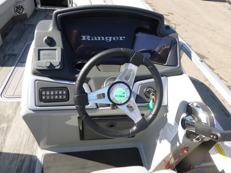 Slide: The Image of 2024 Ranger Reata 223C boat dashboard with steering wheel and control panel. - 8