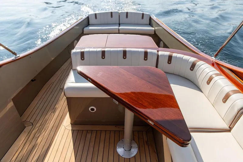 Slide: The Image of 2003 Hinckley Talaria 29R boat interior with elegant wood table and cushioned seating. - 16