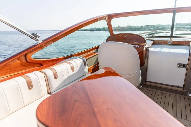 Slide: The Image of 2003 Hinckley Talaria 29R interior with elegant wood and leather detailing, overlooking serene waters. - 17