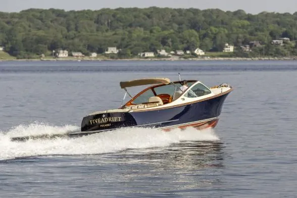 Slide: The Image of 2003 Hinckley Talaria 29R cruising on a calm lake with scenic shoreline. - 3