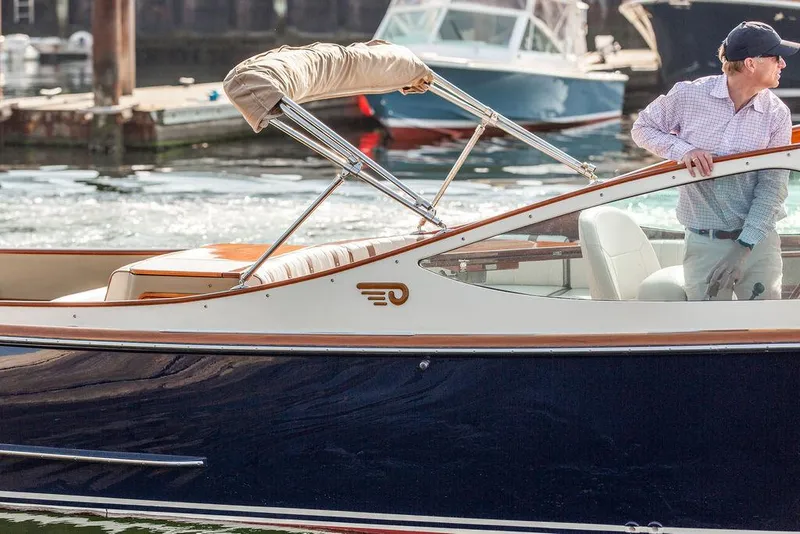 Slide: The Image of 2003 Hinckley Talaria 29R boat with a person onboard, docked in a marina. - 10