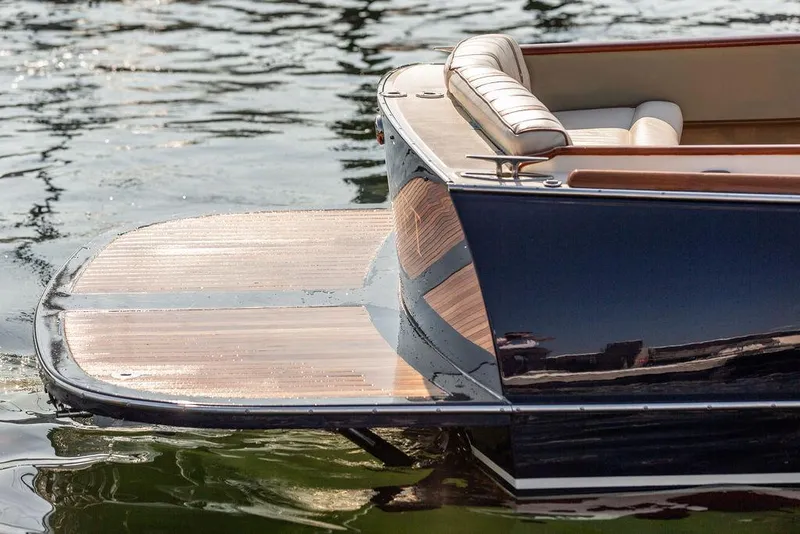 Slide: The Image of 2003 Hinckley Talaria 29R boat with wooden deck, reflecting on water. - 11