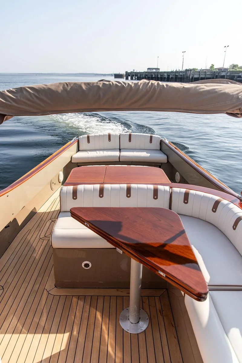 Slide: The Image of Hinckley Talaria 29R 2003 boat interior with elegant wood and white seating. - 13