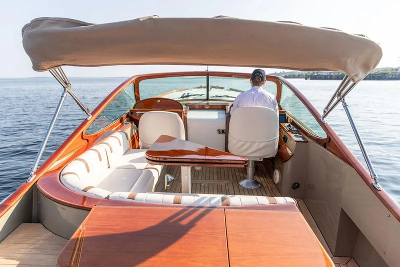 Slide: The Image of 2003 Hinckley Talaria 29R boat interior with seating and helm, cruising on calm water. - 15