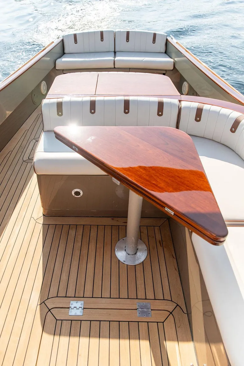 Slide: The Image of 2003 Hinckley Talaria 29R boat interior with wooden table and cushioned seating. - 18