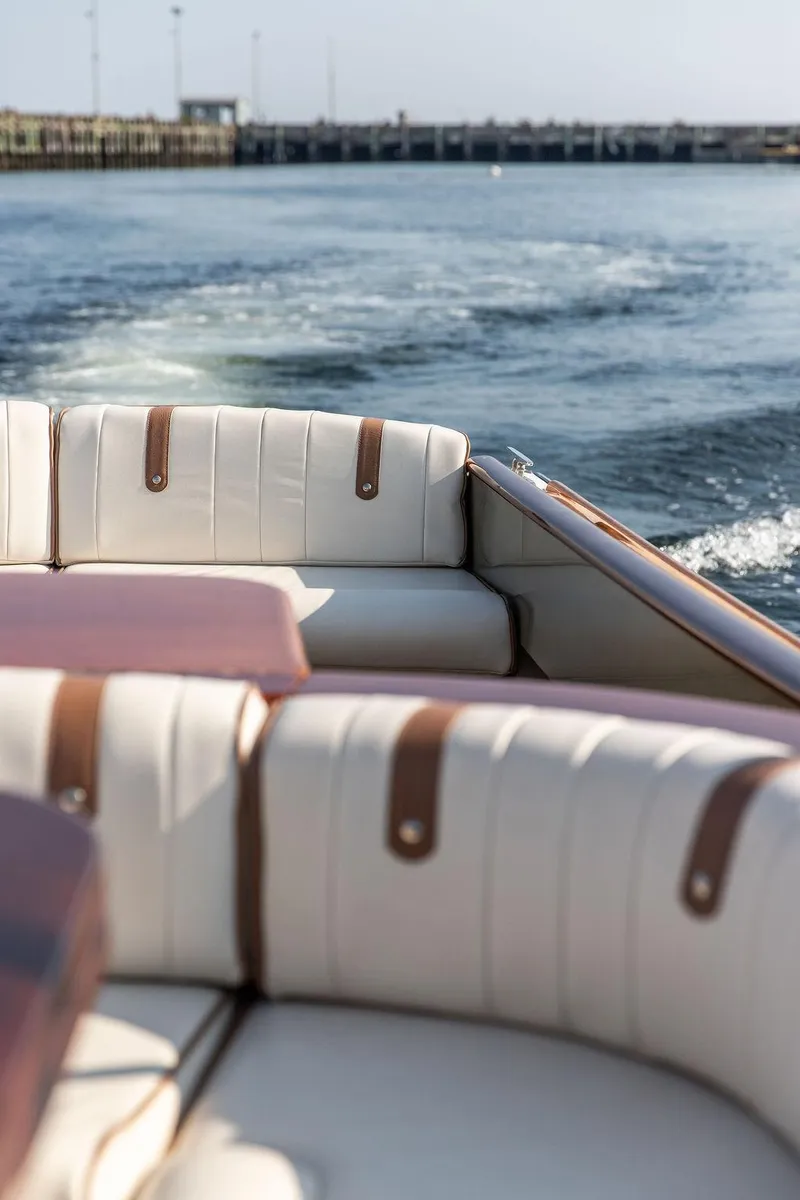 Slide: The Image of 2003 Hinckley Talaria 29R boat interior with white leather seating on open water. - 20