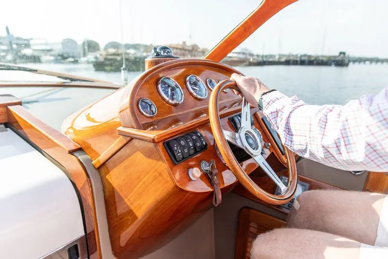 Slide: The Image of 2003 Hinckley Talaria 29R helm with wooden dashboard and steering wheel on a sunny day. - 26