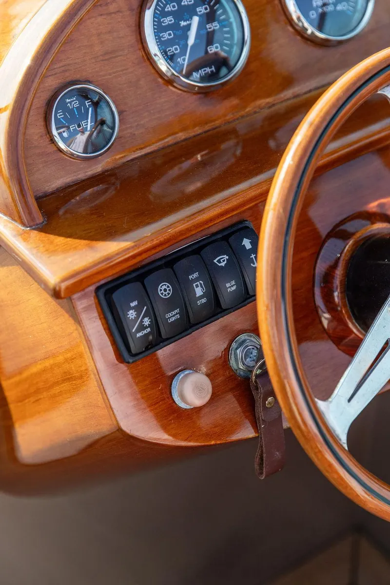 Slide: The Image of 2003 Hinckley Talaria 29R dashboard with wooden finish and control switches. - 29